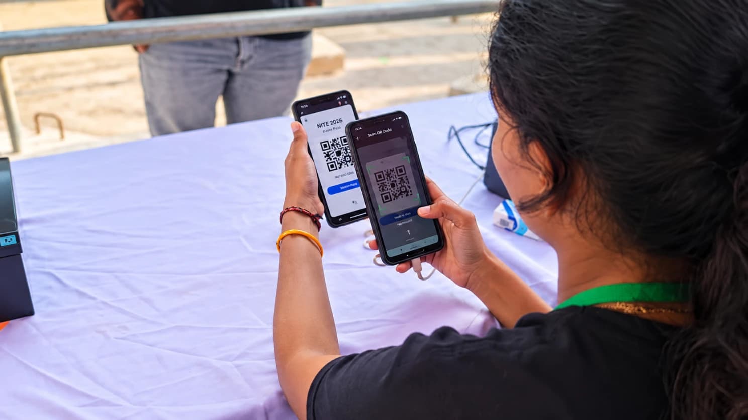 A gate volunteer scans a visitor’s NITE 2026 QR pass with the ExpoLiz scanner on her phone